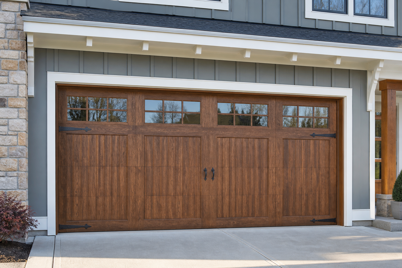 Carriage house style garage door with decorative hardware and raised panels