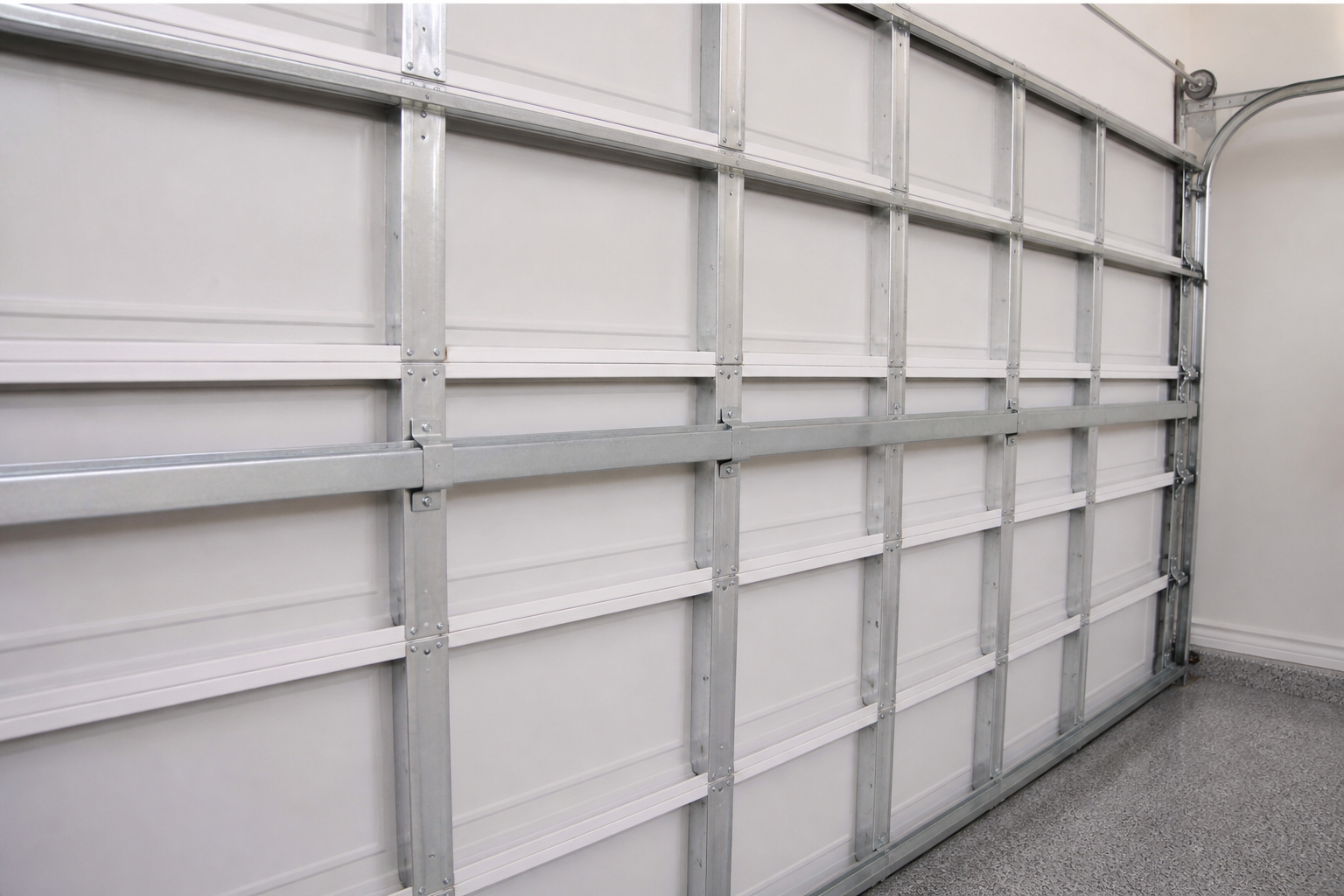 Horizontal steel strut reinforcing a wide residential garage door section